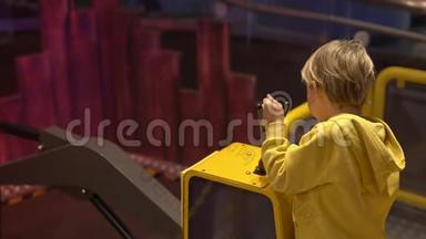一个小男孩参观儿童科学博物馆的慢镜头。 男孩玩挖掘机的模型。 儿童